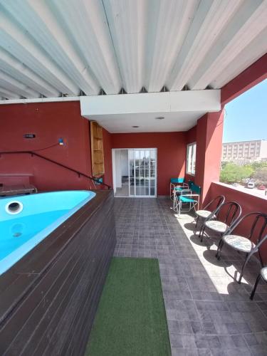 特尔马斯德里奥翁多Plaza的游泳池位于带红色墙壁和椅子的房间