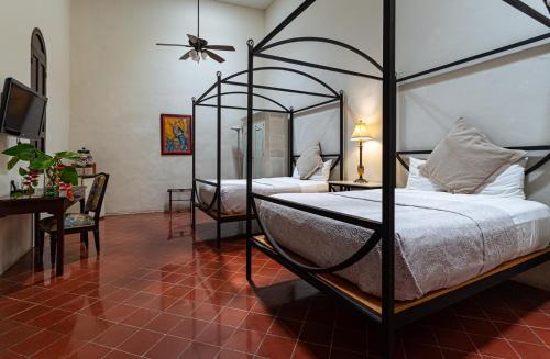 梅里达VILLA MERIDA BOUTIQUE HOTEL - Adults Only的一间卧室配有两张床和吊扇