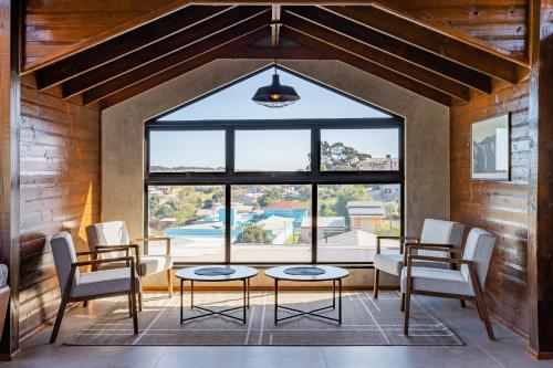 坎巴拉Pousada Serra Verde的客房设有桌椅和大窗户。