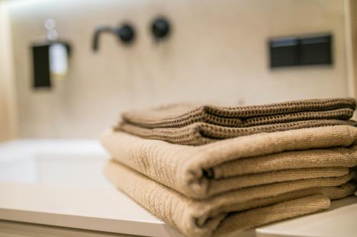 托伦Apartament Migdałowy的浴室的台面上摆放着一堆毛巾