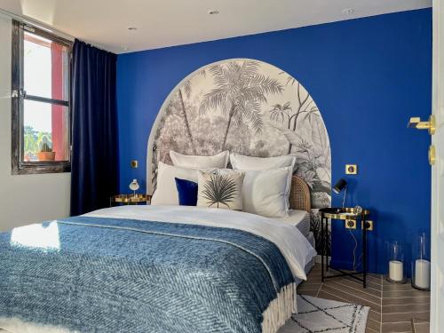 勒博塞Ness Cottage, le calme absolu à 15 minutes des plages的蓝色的卧室设有一张蓝色墙壁的大床