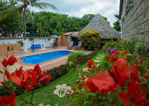 哥伦比亚港Portoazul Casa de Playa的一个带游泳池和茅草屋顶的度假胜地