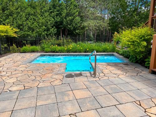 蒙特朗布朗Studio LIV203 by Gestion ELITE的庭院内的游泳池,设有石头庭院