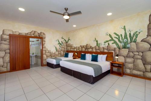 阿约拉港Plaza Luna Suites的一间卧室设有两张床和石墙