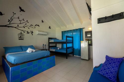 圣安德烈斯阳光海岸宾馆的一间卧室配有床,树上还鸟