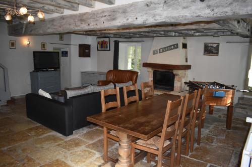 TrézanLe Moulin,19 bis rue de Beaudon, 45330 Augerville la riviere的客厅配有木桌和壁炉
