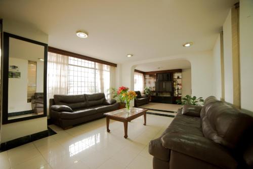波哥大Apartamentos Galerías的客厅配有沙发和鲜花桌