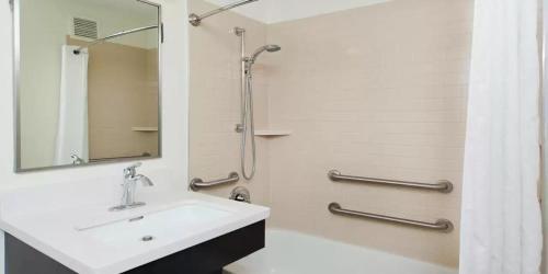 欧弗兰帕克MainStay Suites- Kansas City Overland Park的白色的浴室设有水槽和淋浴。