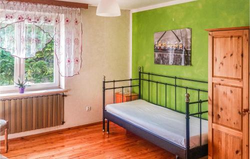 达尔沃沃3 Bedroom Stunning Home In Darlowo的卧室设有一张位于绿色墙壁上的床铺