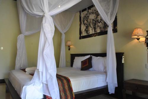 佩母德兰凡卡尔宁简易别墅旅馆的卧室配有带白色窗帘的天蓬床
