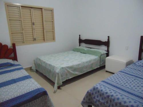 卡皮托利乌Rancho do Pedro的一间卧室设有两张单人床和一个窗户。