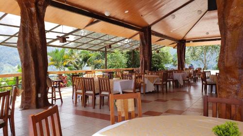 ZamoraHostería Castillo Real的一间空餐厅,配有桌椅和树木