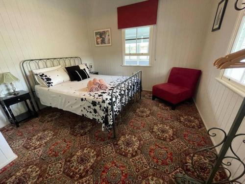 史丹霍普Finney Cottage的一间卧室配有一张床和一张红色椅子
