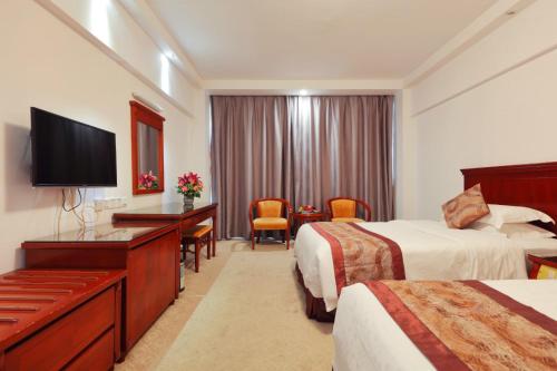 广州广州三寓宾馆的酒店客房设有两张床和一台平面电视。
