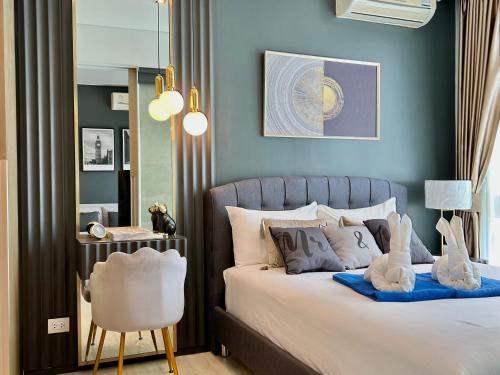 乔木提恩海滩Pattaya Holiday at Veranda Residence Pattaya的一间卧室配有一张带椅子和镜子的床