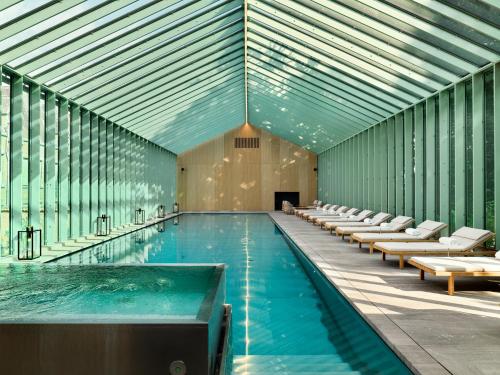 安特卫普Botanic Sanctuary Antwerp - The Leading Hotels of the World的一个带椅子的大型游泳池和一个游泳池