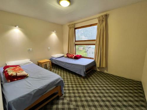 NamcheHotel Camp de Base的酒店客房设有两张床和窗户。