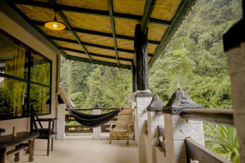武吉拉旺Jungle Inn Bukit lawang的客房设有吊床,享有森林美景。
