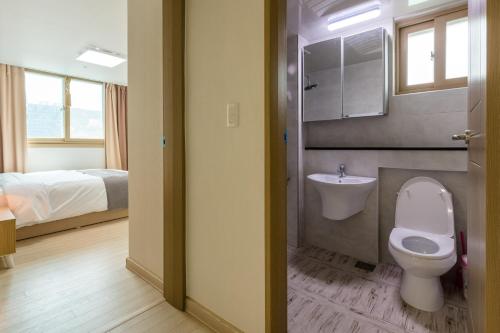 巨济JS Residence Hotel Okpo的一间带卫生间、水槽和床的浴室