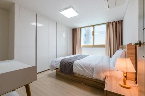 巨济JS Residence Hotel Okpo的一间卧室设有一张床和一个窗口
