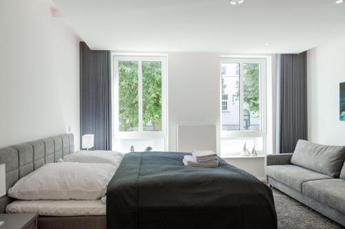 瓦尔内明德LIGHTHOUSE APPARTEMENTS的一间卧室配有一张床、一张沙发和窗户。