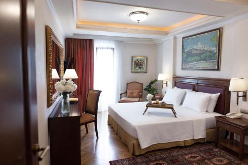 雅典雅典伊莱克特拉宫的酒店客房,配有一张床、一张桌子和椅子