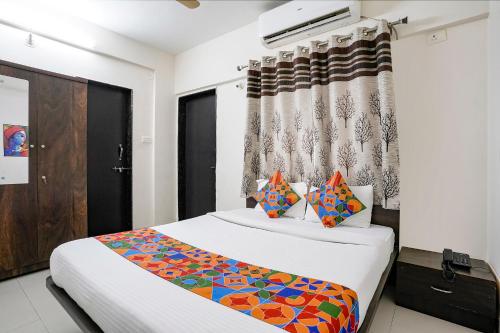 DāpuriFabHotel Vardhan House II的一间卧室配有床和窗帘