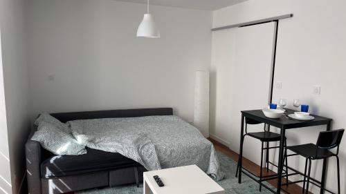 普瓦捷Les Studios de Clément的一间卧室配有一张床和一张边桌
