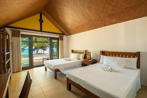 圣胡安Virgin Beach Resort的一间卧室设有两张床和大窗户