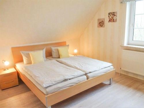 佩尔沃姆Hus-Pellworm-2-Ferienwohnung-Meereswelle的一间卧室配有一张带白色床单和黄色枕头的大床。