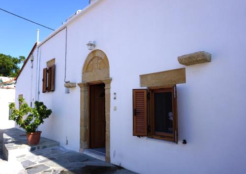 帕拉代西翁Amalia's Traditional Home in Paradisi的白色的建筑,有门和窗户