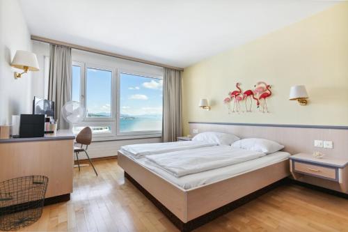 韦登斯维尔becozy du Lac Self-Check In Hotel Riviera Edition的一间卧室设有一张床和一个大窗户