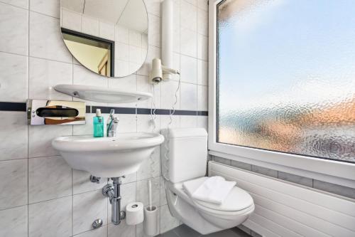 韦登斯维尔becozy du Lac Self-Check In Hotel Riviera Edition的一间带水槽、卫生间和镜子的浴室