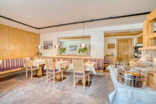 施图本阿尔贝格Landhaus Maria的一间设有白色桌椅的用餐室