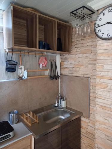 卡塔海滩Kata Happy Place的厨房配有水槽和墙上的时钟