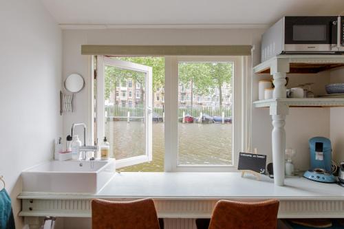 阿姆斯特丹The Amsterdam Houseboat Family - de Jordaan的一个带水槽和大窗户的厨房