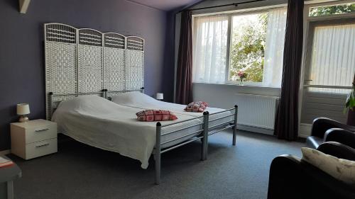 温特斯韦克Vakantiewoning De Berkeboom的一间卧室设有一张床和两个窗户。