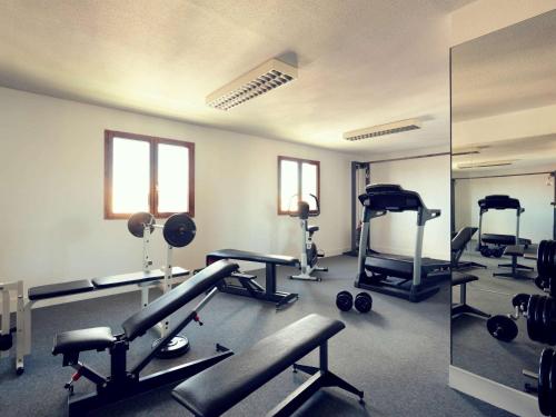 佩皮尼昂佩皮尼昂中心美居酒店的一间健身房,里面装有几台跑步机和举重器材