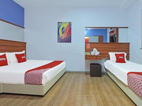 瓜拉丁加奴Super OYO 768 Fajar Baru Boutique Hotel的客房配有两张带红白色枕头的床。