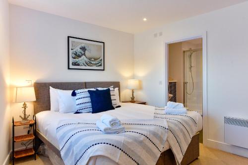 斯旺西Just Stay Wales - Meridian Tower Marina & City View - 2 Bed Apartment的一间卧室配有一张带蓝白色枕头的大床