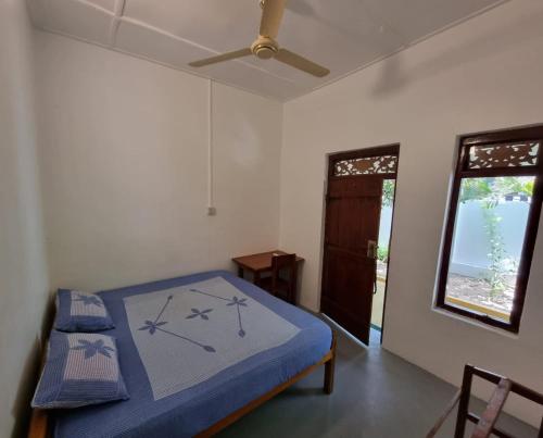 阿鲁甘湾Another World的一间卧室设有一张床、一个窗口和吊扇