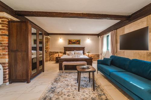 波德戈里察Casa Ra的客厅配有蓝色的沙发和床。