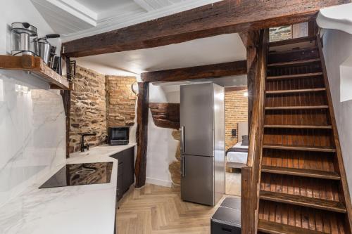 雷恩LE SAINT LOUIS - Apt 3 chambres au cœur de Rennes的一间设有楼梯和冰箱的厨房