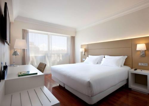 潘普洛纳NH潘普洛纳伊鲁纳公园酒店的酒店客房设有一张白色大床和一个窗户。