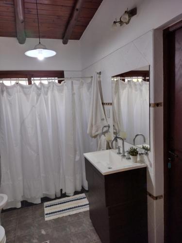 圣萨尔瓦多德朱CampoMora- 5 min del Centro - CONFORT - Parrilla & Pileta的浴室设有水槽和白色的淋浴帘
