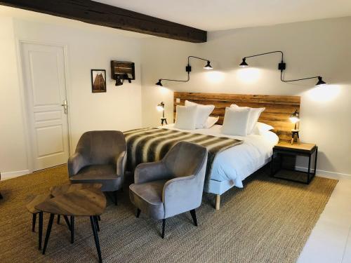 塞莱斯塔Zewwelatreppler - La Grange aux Petits Oignons - Chambre Cigogne的一间卧室配有一张大床和两把椅子