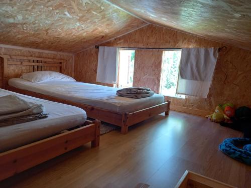 帕特里莫尼奥Casa di legnu ,charmant chalet avec piscine的小木屋内一间卧室,配有两张床