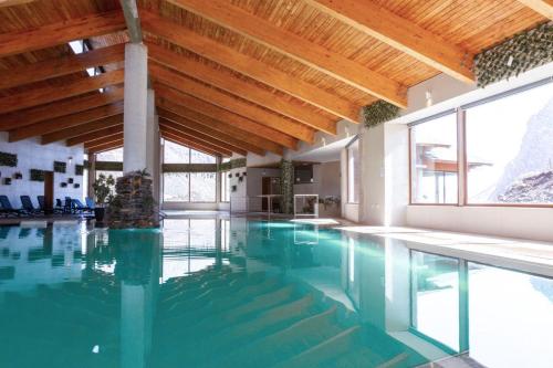 Refugio Lo ValdésLodge El Morado的一个带木制天花板的室内游泳池和一个游泳池