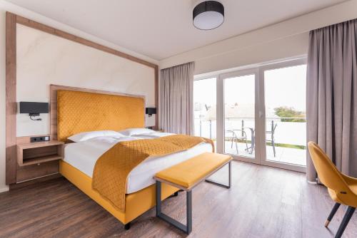 ViechtHotel Traunfall的酒店客房设有一张床和一个阳台。