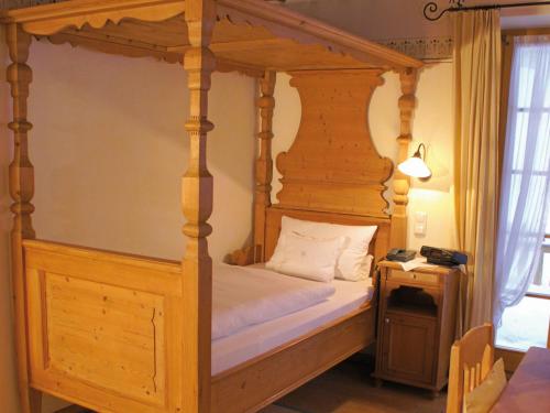 巴特特尔茨贝内迪科滕霍夫乡间别墅酒店的一间卧室配有一张木天蓬床和床头柜